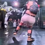 Robô humanoide lutando contra um humano numa jaula