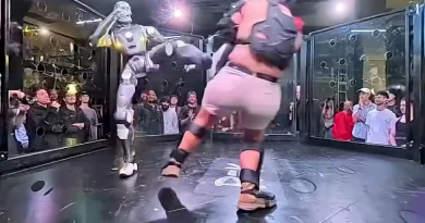 Robô humanoide lutando contra um humano numa jaula
